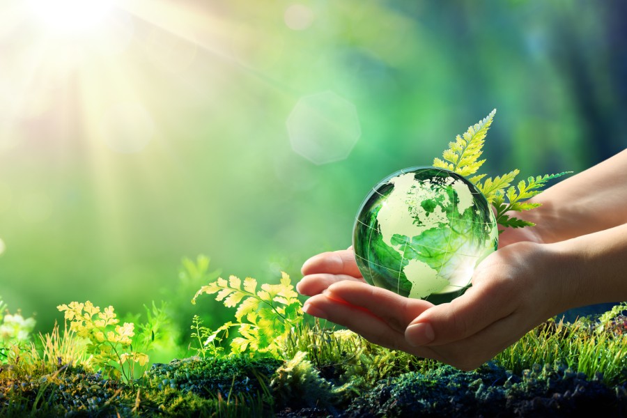 Nachhaltige Mitgliedschaften und Initiativen: UN PRI. Hände halten Erdkugel aus Glas in Sonne.