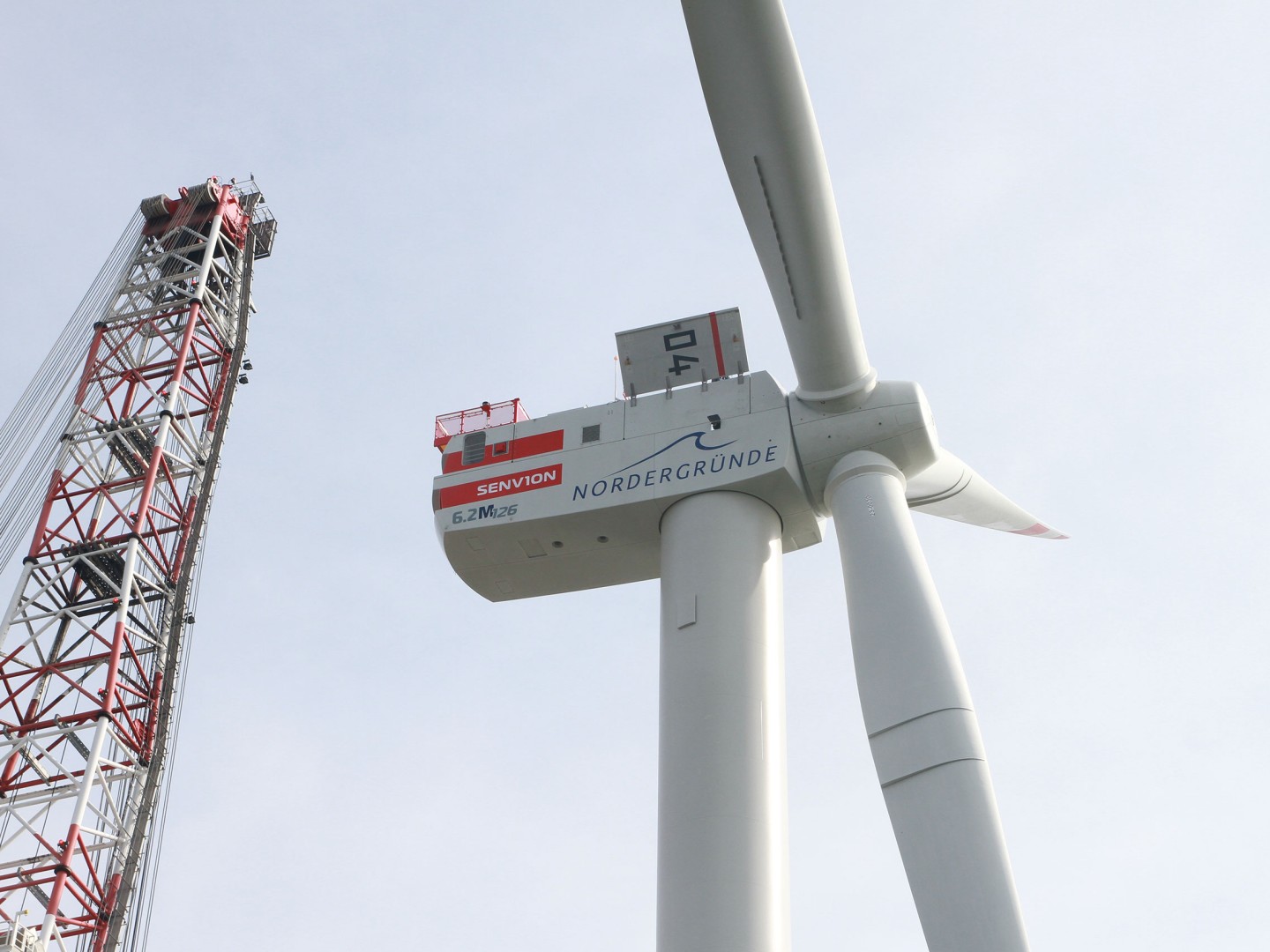 Nachhaltige Investitionen im Bereich Infrastruktur: Windrad eines Off-Shore-Windparks mit Kran. 
